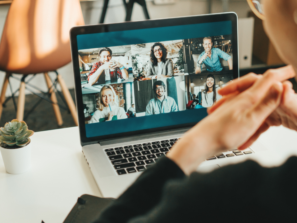 Videochiamata con sei partecipanti su schermo di laptop durante una riunione online