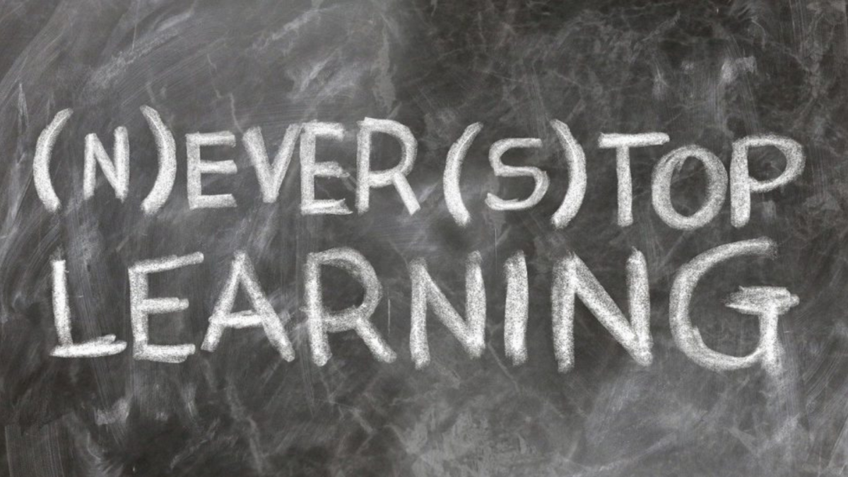 Lavagna con la scritta gessata «(N)ever (s)top learning»