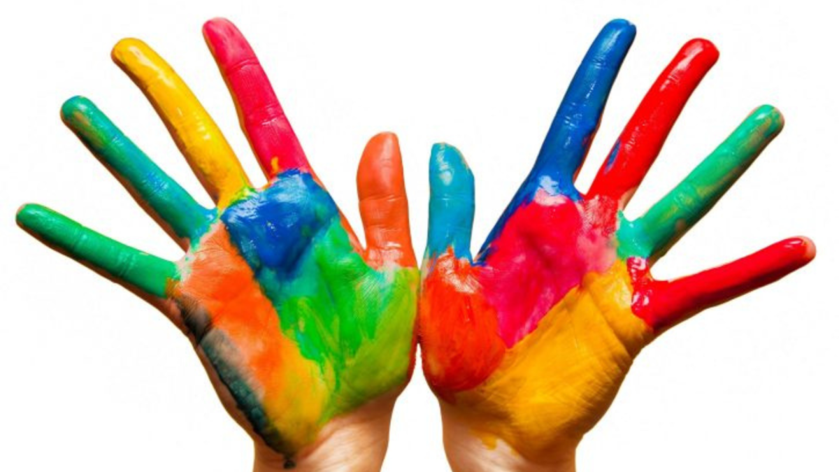 Due mani dei bambini dipinte con colori vivaci a palmo aperto