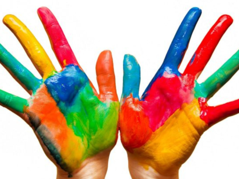 Due mani dei bambini dipinte con colori vivaci a palmo aperto