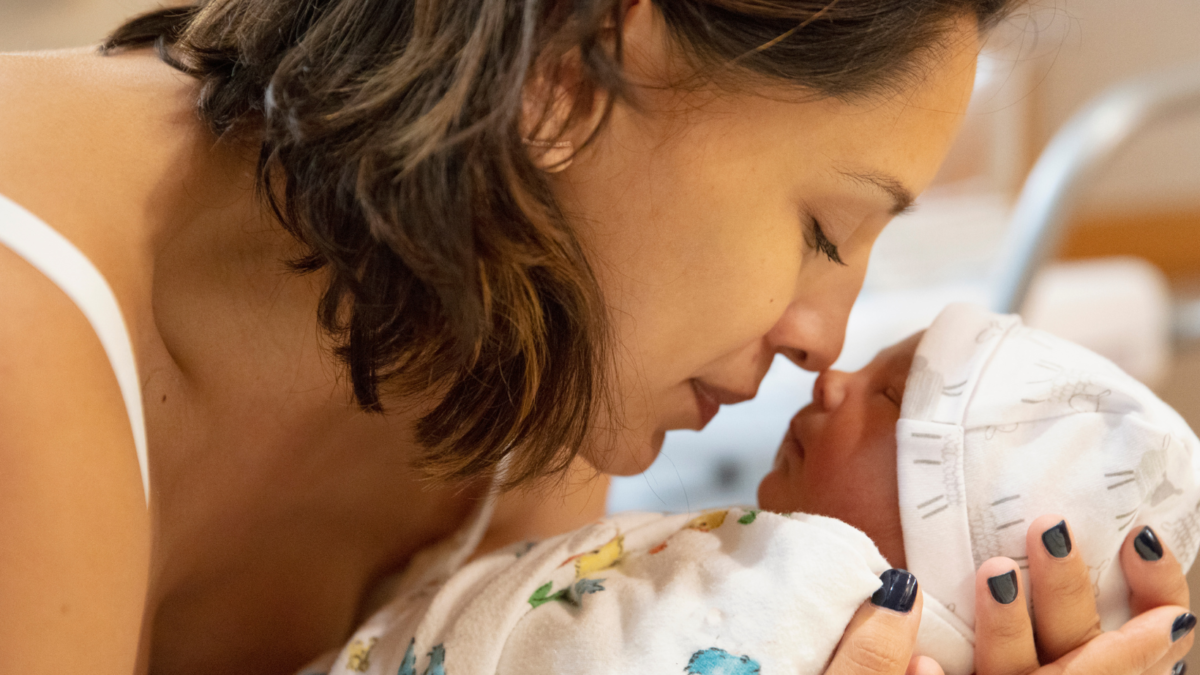 Una madre tiene in braccio il suo neonato guancia a guancia