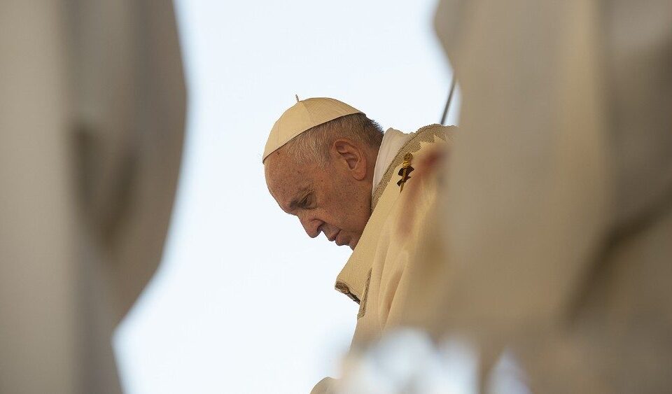 Papa Francesco a capo chino durante un momento di preghiera all'aperto