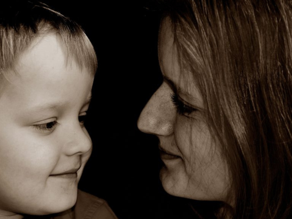 Foto in bianco e nero di una madre e un bambino che si guardano negli occhi