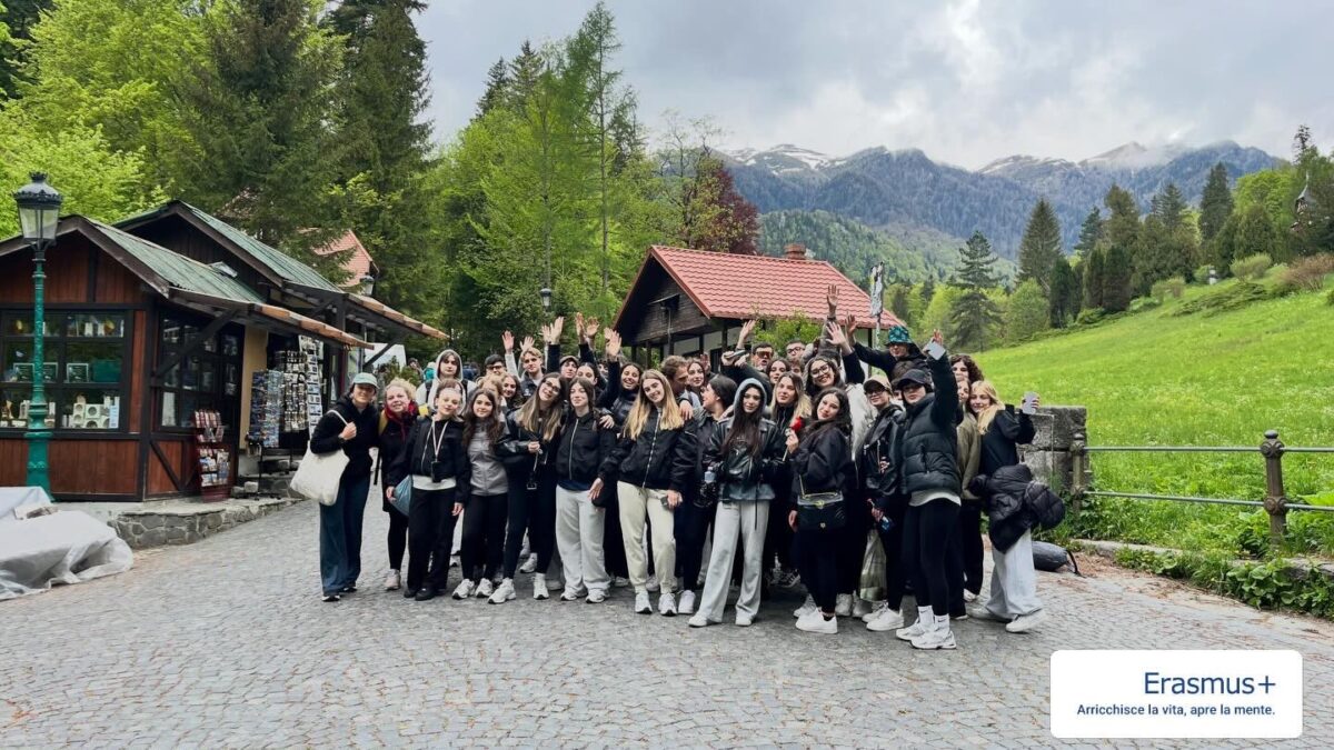 Gruppo di studenti in gita Erasmus+ in montagna, con cartello "Erasmus+ arricchisce la vita, apre la mente"