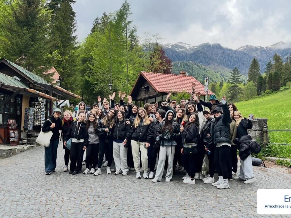 Gruppo di studenti in gita Erasmus+ in montagna, con cartello "Erasmus+ arricchisce la vita, apre la mente"