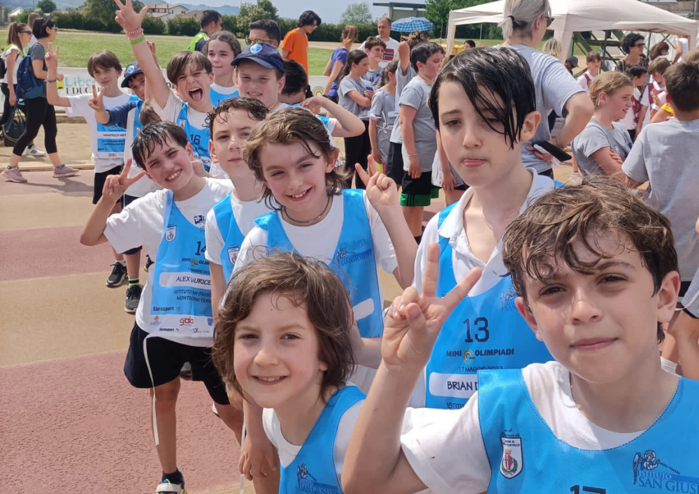Gruppo di studenti con pettorine azzurre festeggia alle Miniolimpiadi